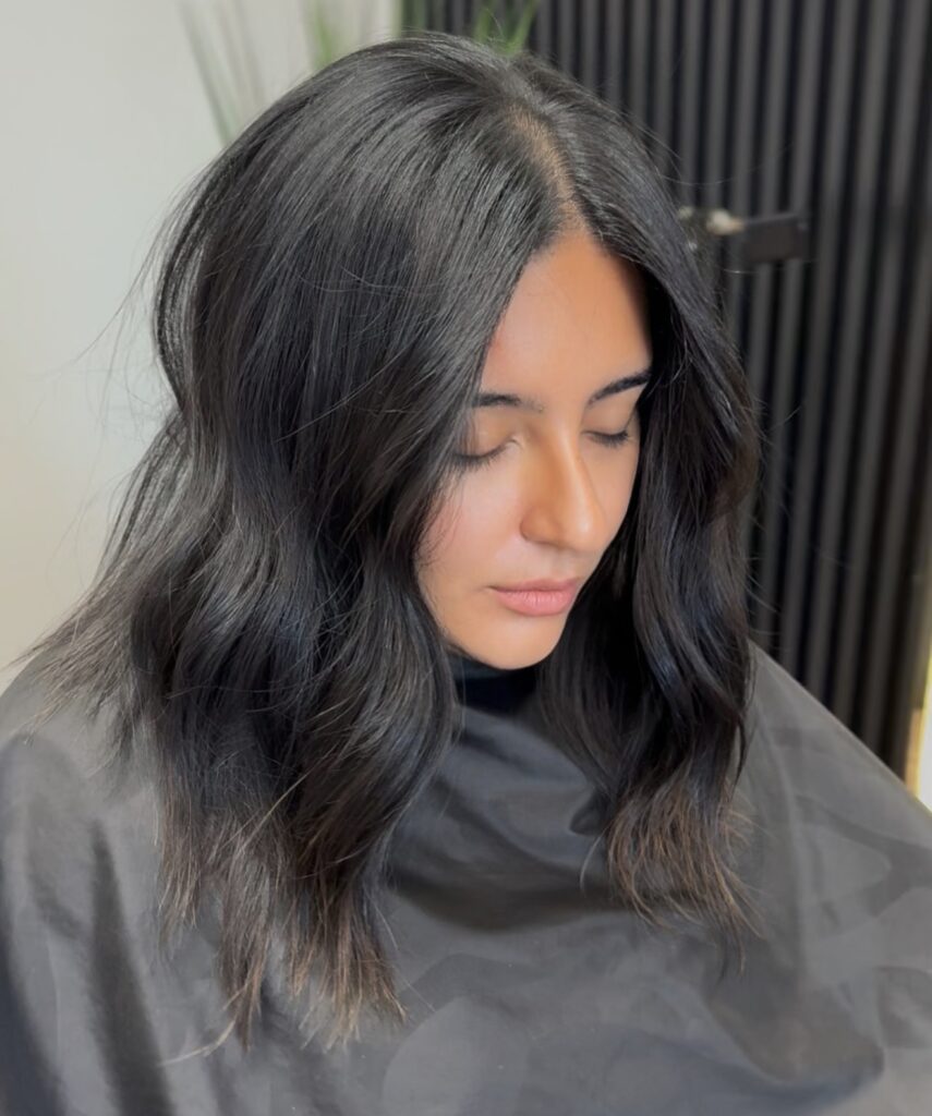 Dark wavy long bob with a center part and soft natural movement.