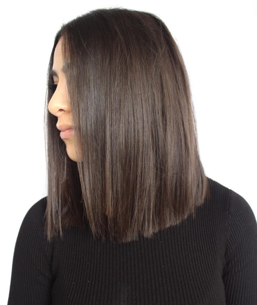 A woman with a sleek, shoulder-length, ash-brown, blunt, long bob styled straight with a middle part.