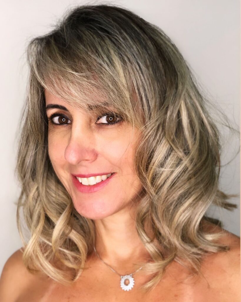 A textured wavy lob with warm blonde tones and soft layers.