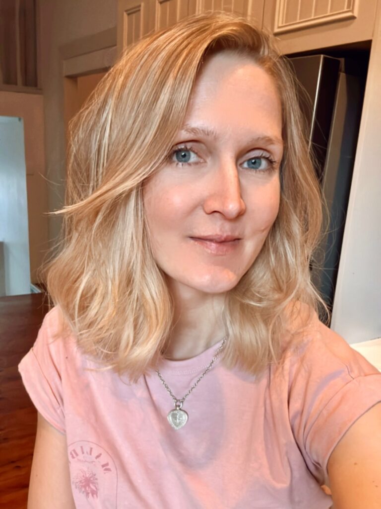 Shoulder length blonde lob with soft waves and a side part.