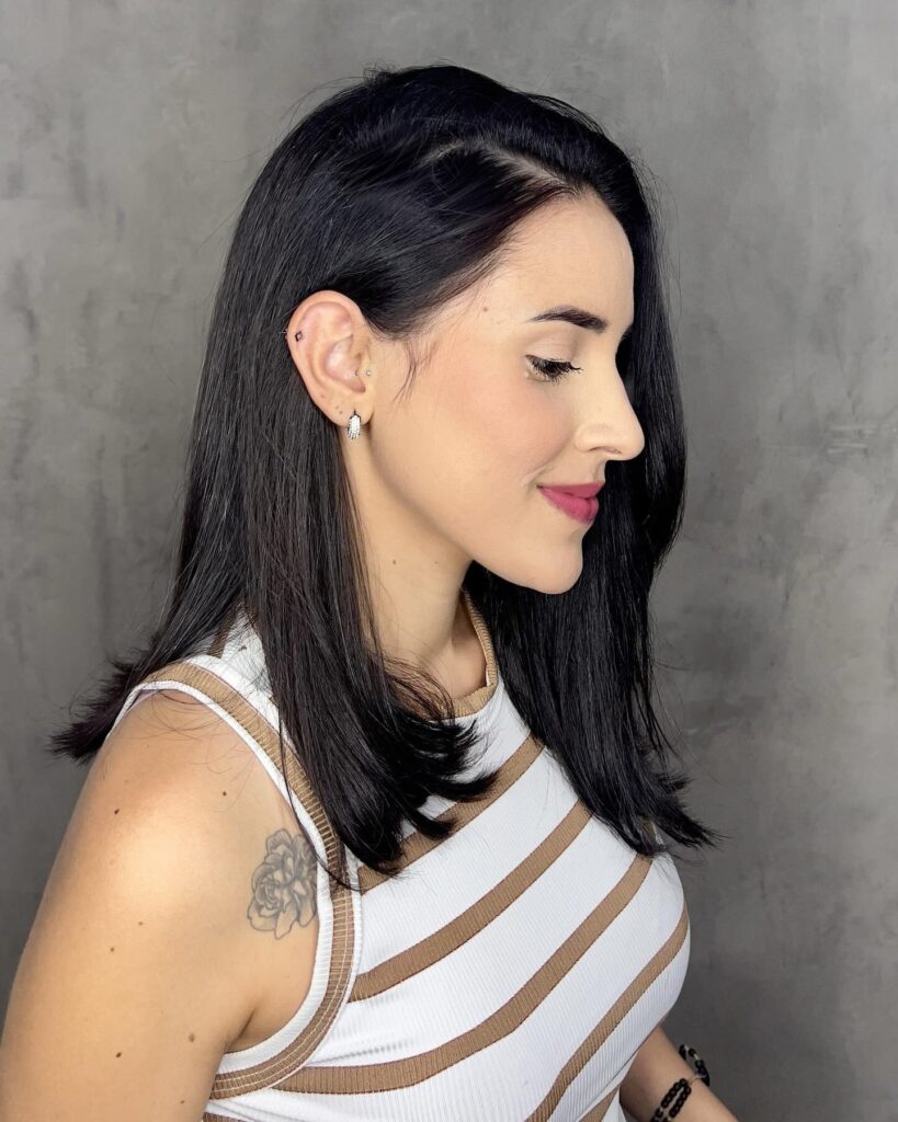 Sleek long bob with a deep side part and softly tucked ends.
