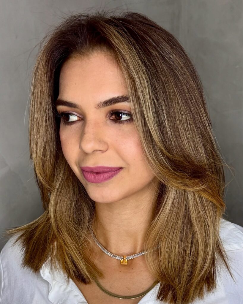 Honey brown layered lob with soft highlights and a smooth finish.