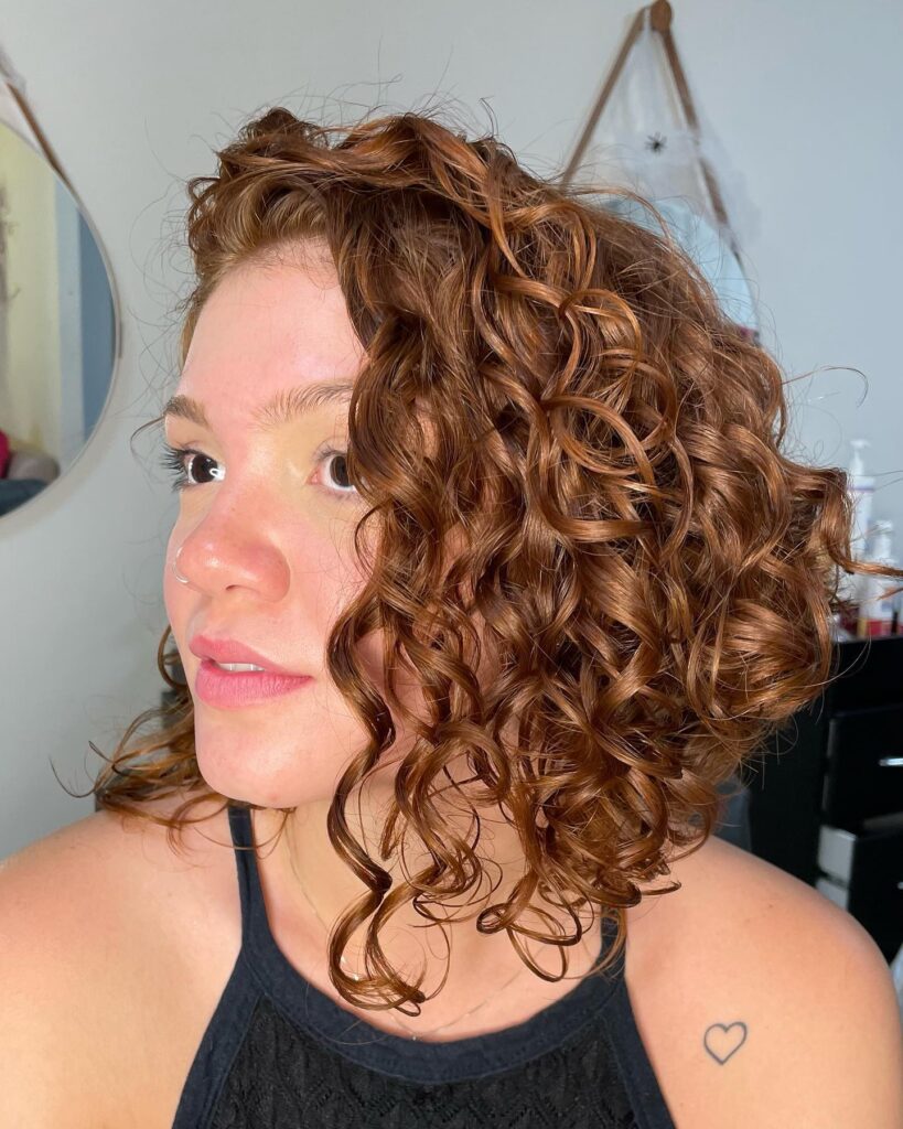 Curly long bob with defined ringlets and a rich copper color.