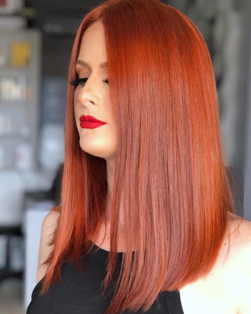 Straight copper long bob with a sleek smooth finish and shoulder length cut.
