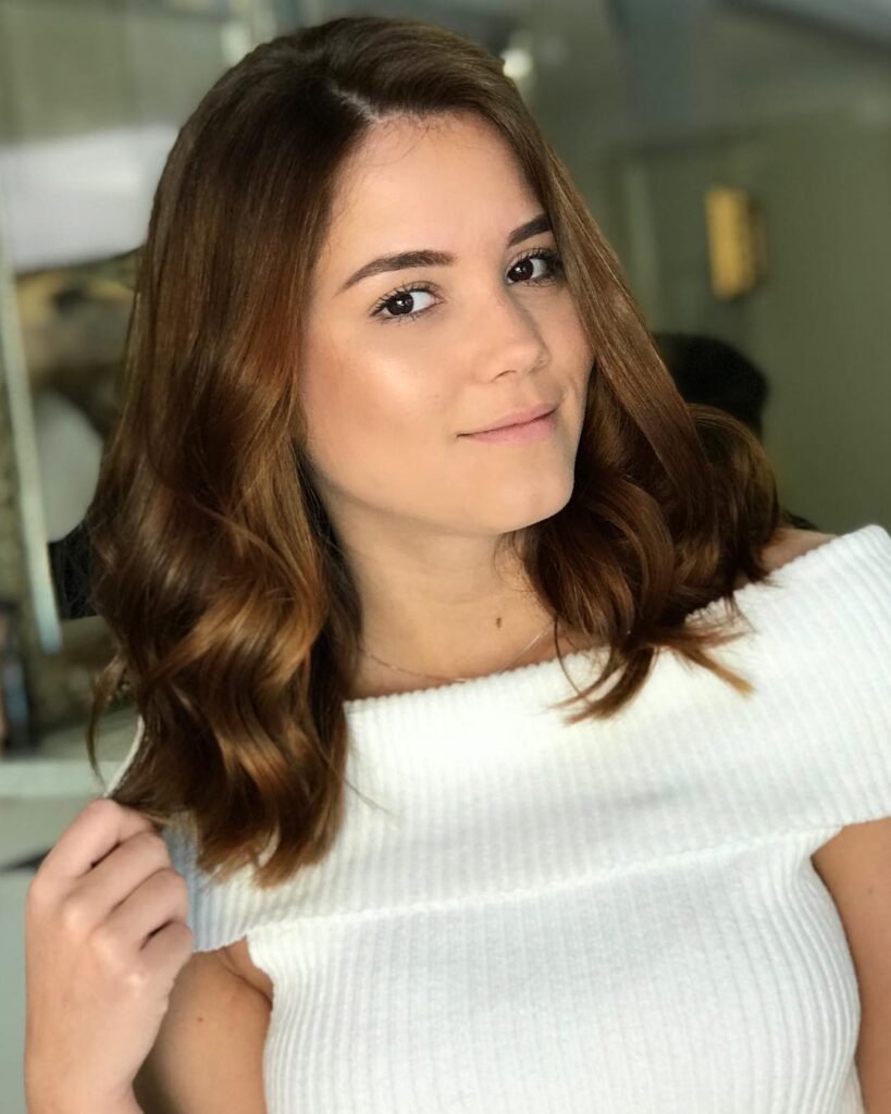 Chestnut brown long bob with loose waves and a soft side part.