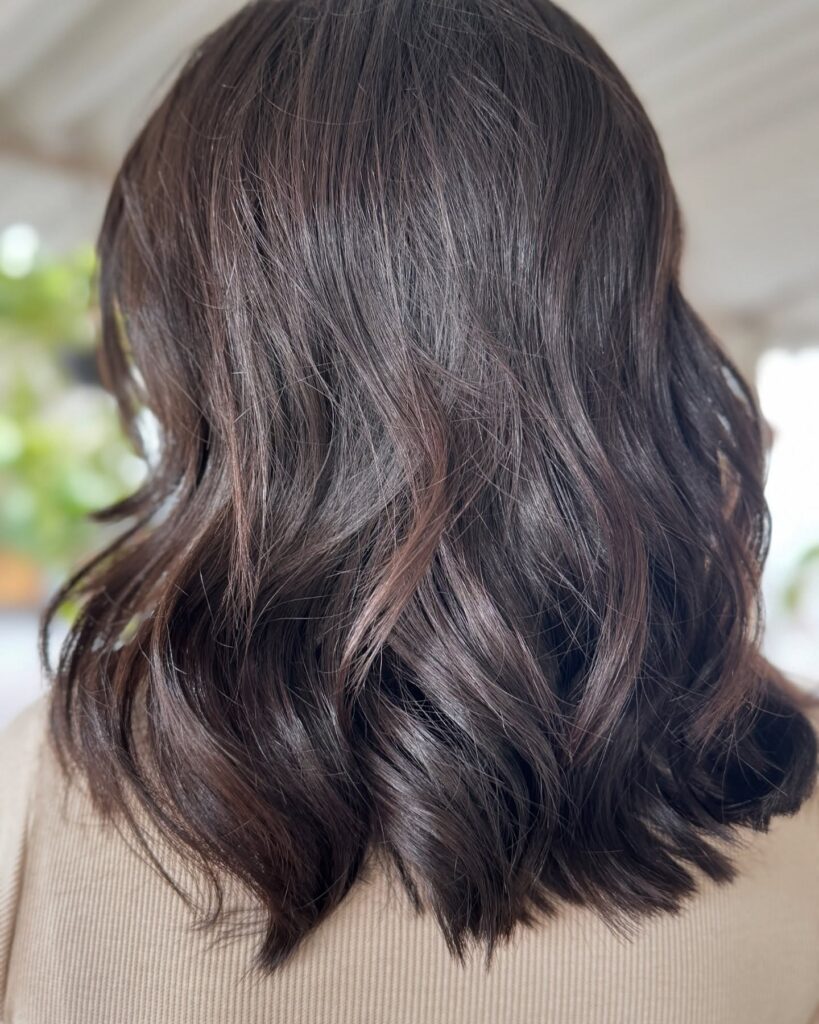 Dark brown long bob with soft glossy waves and a smooth finish.