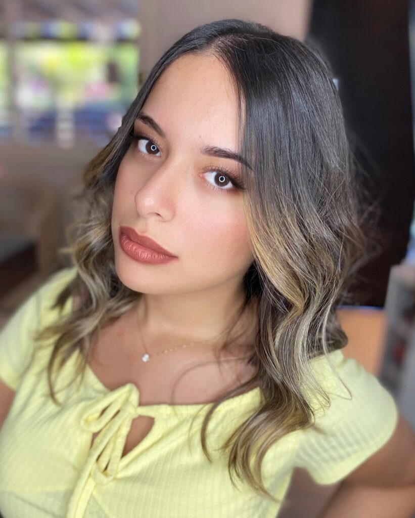 Wavy long bob with a center part and soft face framing highlights.