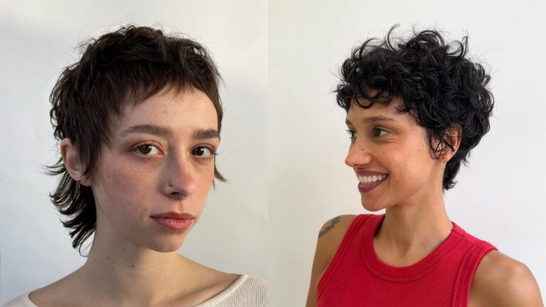 Short curly pixie hairstyle with textured layers, wispy bangs, and slightly longer pieces at the nape for a soft playful finish.