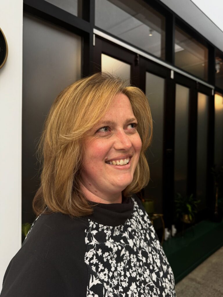 Honey blonde layered bob with soft feathered ends and side parted styling.