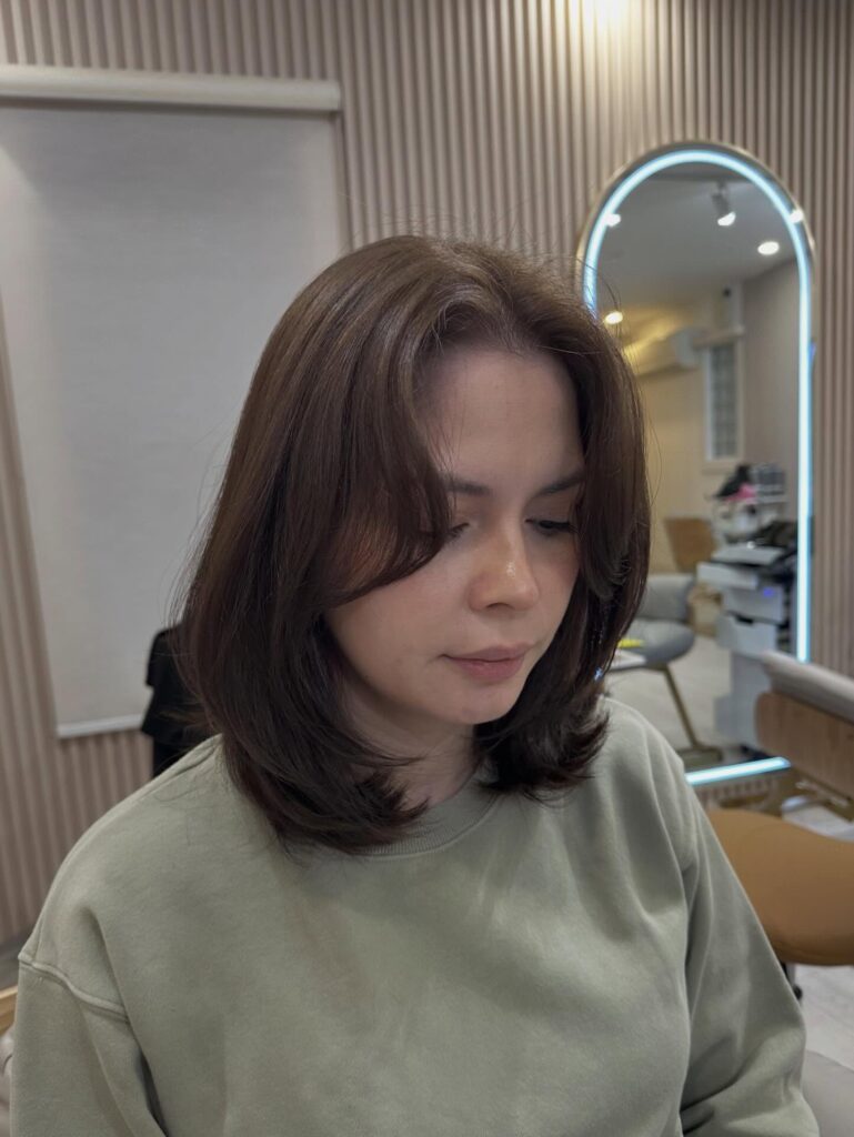 Dark brunette layered bob with curtain layers and softly flipped ends.