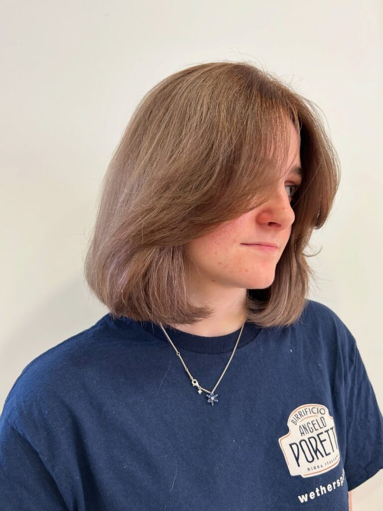 Shoulder length mushroom brown layered bob with soft face framing layers.