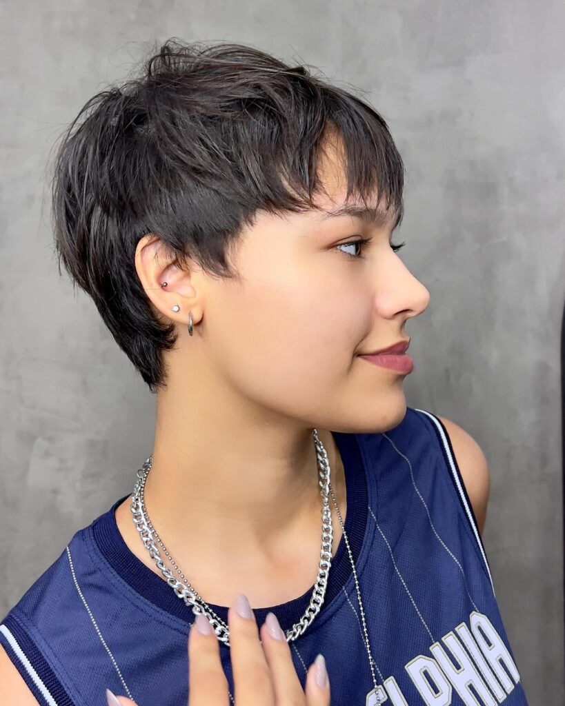 Short brunette pixie crop with feathered layers and a tapered back.