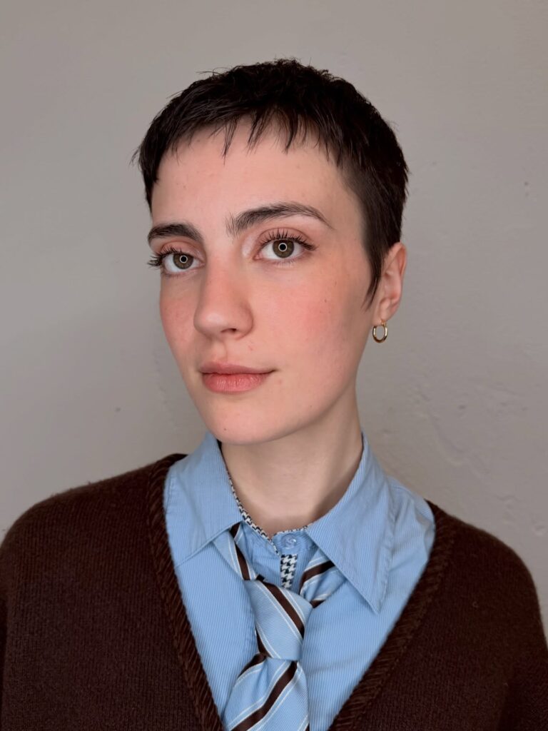 Very short brunette pixie haircut with fine textured layers and a cropped fringe.