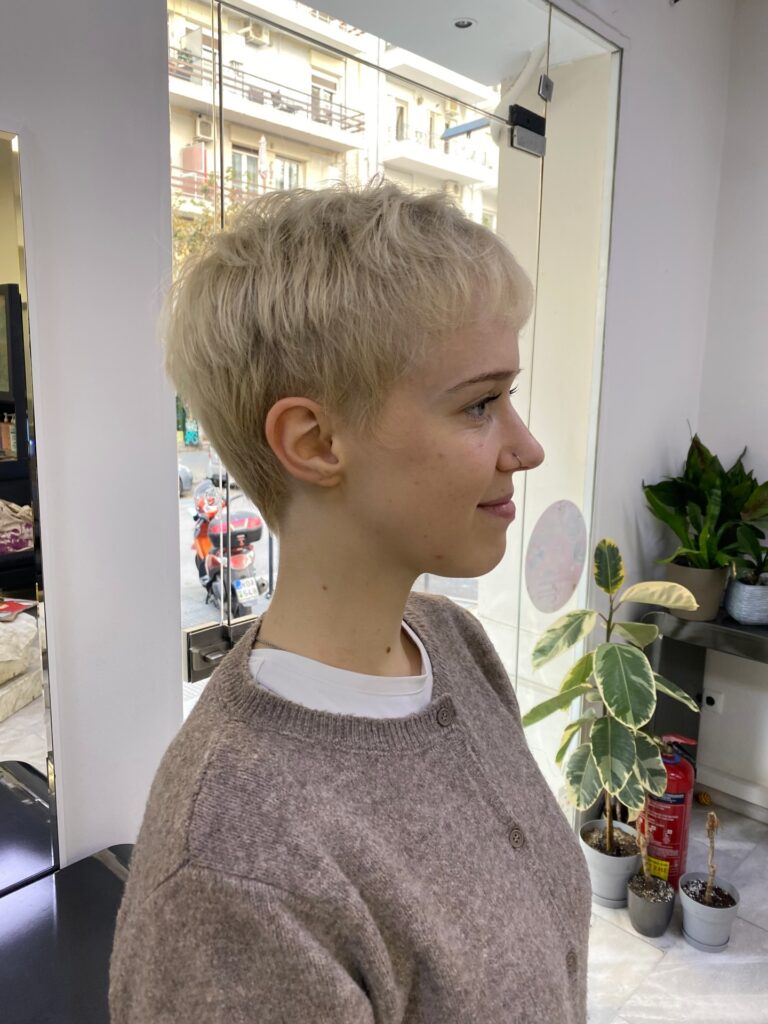 Short frosted blonde pixie haircut with feathered layers and soft texture.