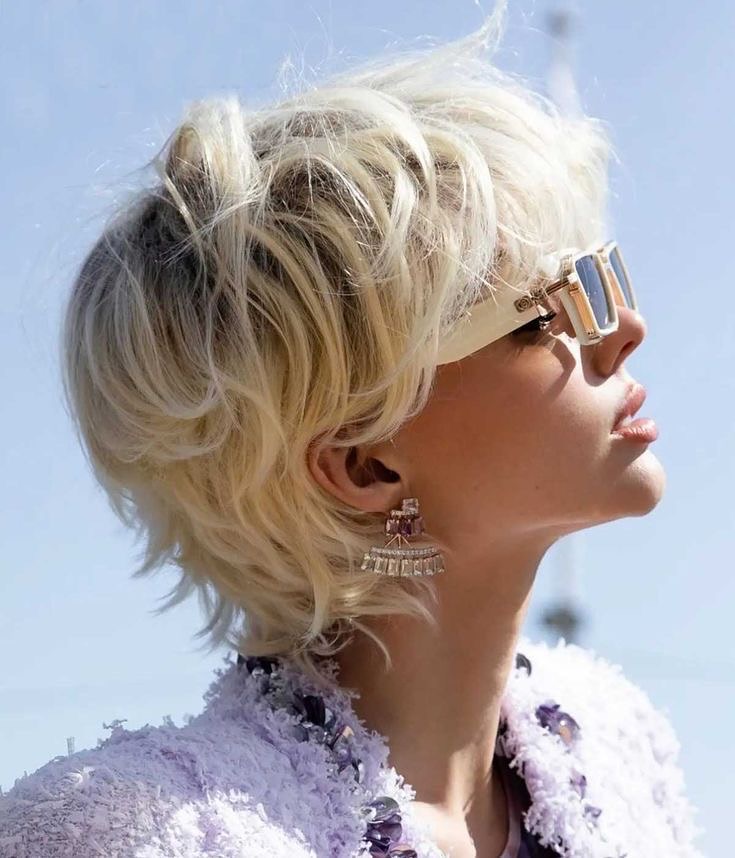 Platinum blonde pixie haircut with airy layered volume and soft flipped out ends.
