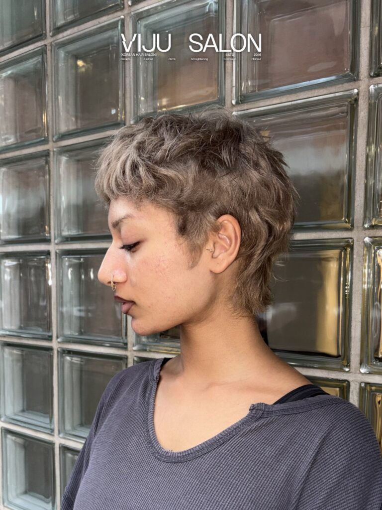 Ash blonde pixie mullet with choppy textured layers and a soft undercut.