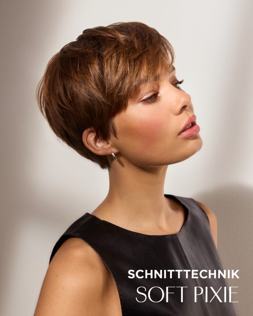 Soft brunette pixie haircut with side swept fringe and rounded layered shape.