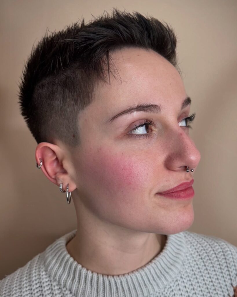 Short spiky pixie haircut with faded sides and textured dark layers on top.