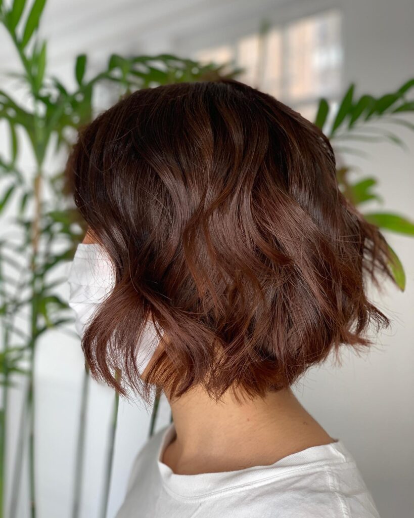A rich mocha brown bob with soft waves and lightly choppy ends.