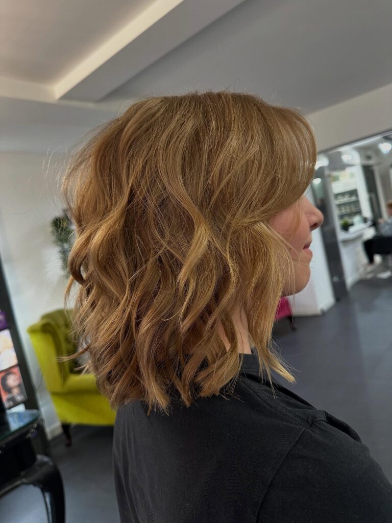 A honey caramel lob with loose textured waves and choppy layers.