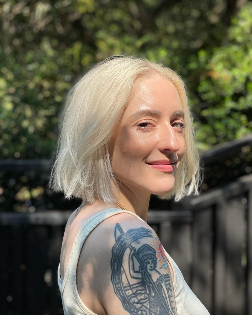 A chin length icy blonde choppy bob with soft texture and lightly feathered ends.