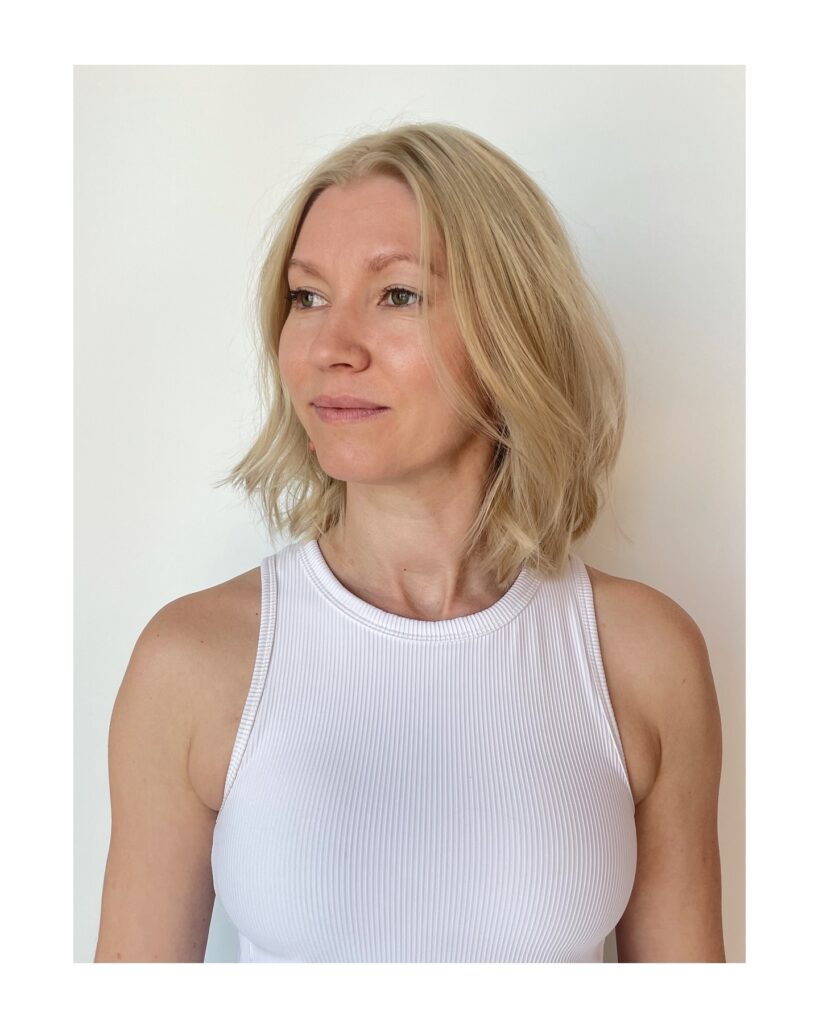 A champagne blonde choppy bob with soft waves and a center part.