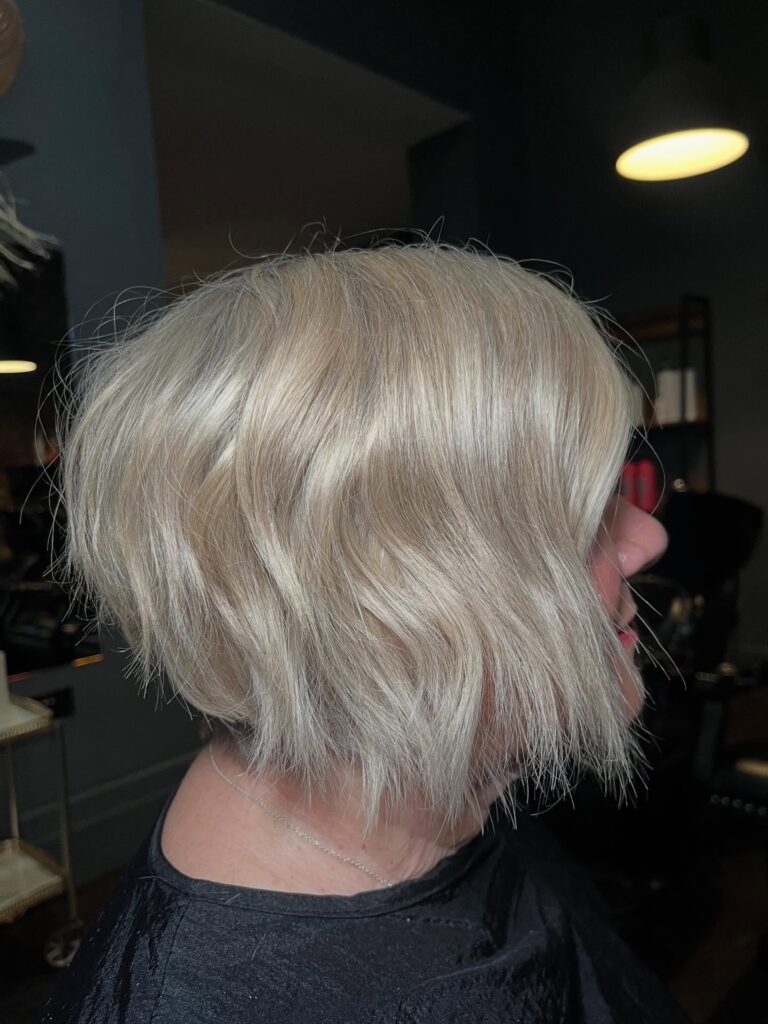 A platinum blonde choppy bob with razored textured ends and soft waves.