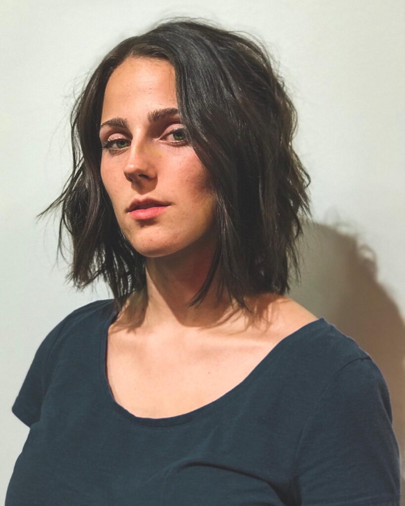 Dark brown tousled layered bob with soft waves and textured ends.