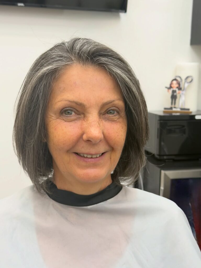 Rounded gray layered bob with soft volume and blended silver highlights.