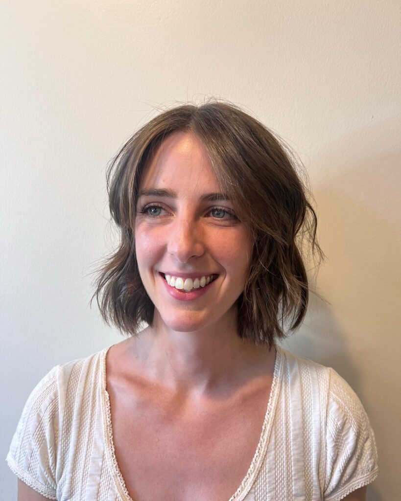 Medium brunette wavy bob with soft face-framing layers.