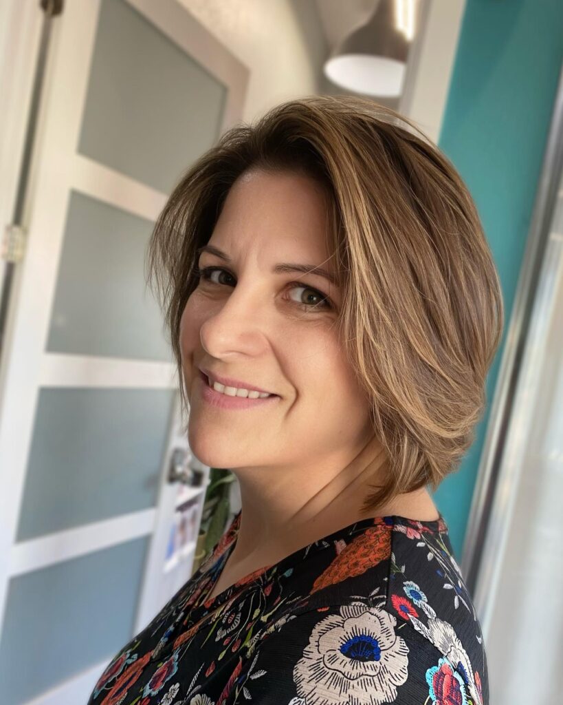 Honey brown feathered layered bob with soft volume and tapered ends.
