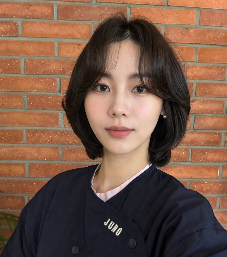 A soft Korean-style dark layered bob with airy face-framing layers.