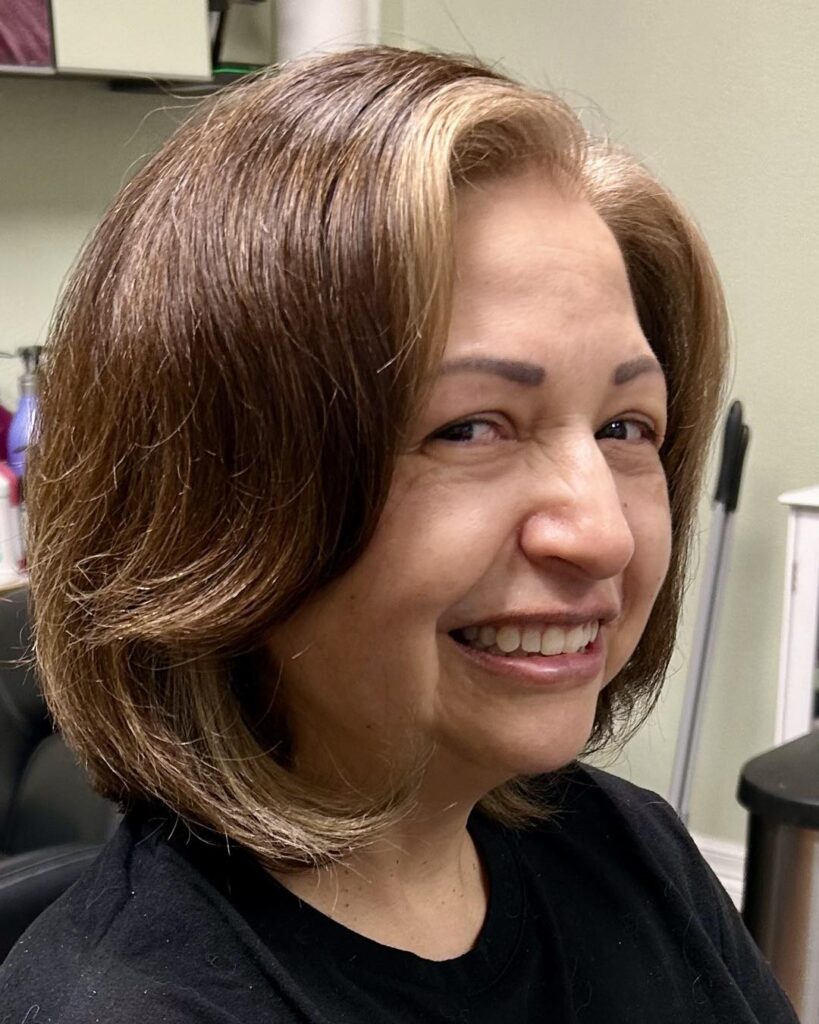 A rounded layered brunette bob with honey-toned shine and soft volume.
