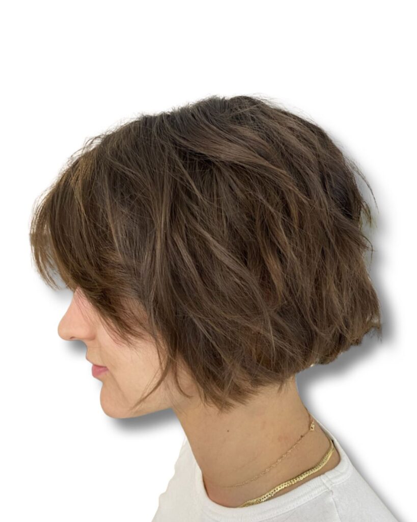 A tousled brunette bob with piecey textured layers and soft volume.