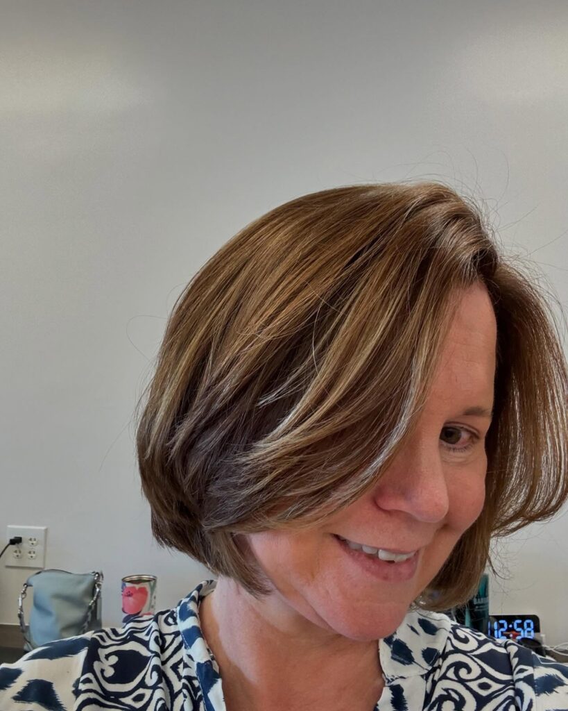 A brunette layered bob with blonde face-framing highlights and beveled ends.