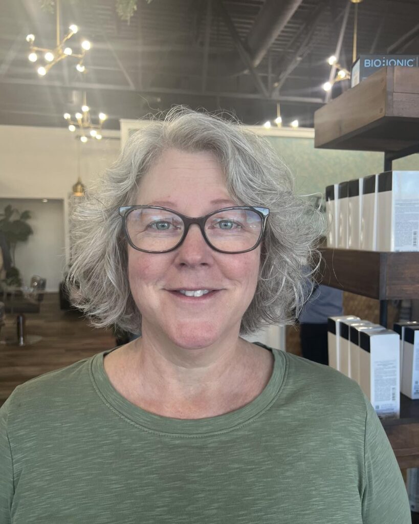Short silver layered bob with fluffy waves and soft feathered volume around the face.