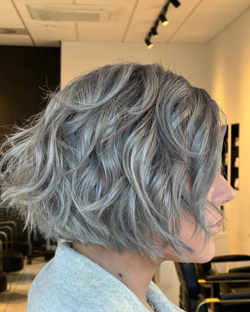 Short icy silver layered bob with tousled waves and textured flipped ends.