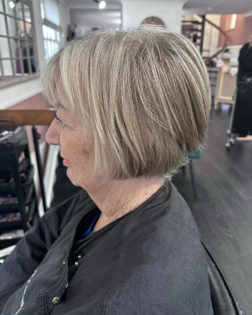 Classic chin-length ash blonde bob with soft layers and a smooth, rounded shape.