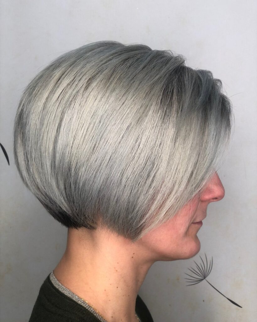 Smooth graduated ash blonde bob with stacked layers and longer angled front sections.