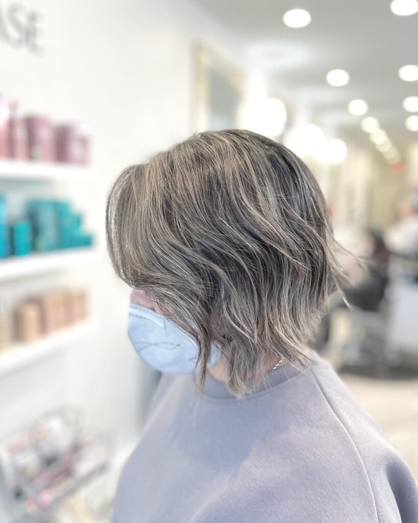 Textured ash blonde bob with choppy layers, soft waves, and dimensional cool-toned highlights.