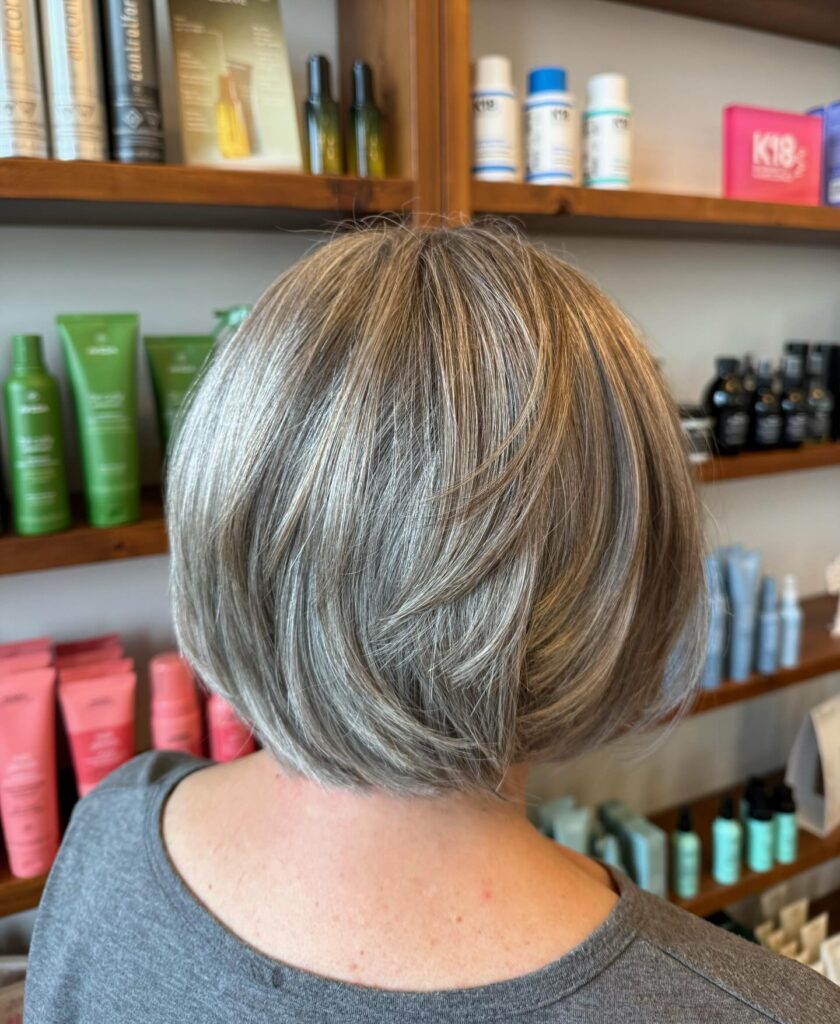 Rounded ash blonde layered bob with glossy dimension and soft volume through the back.