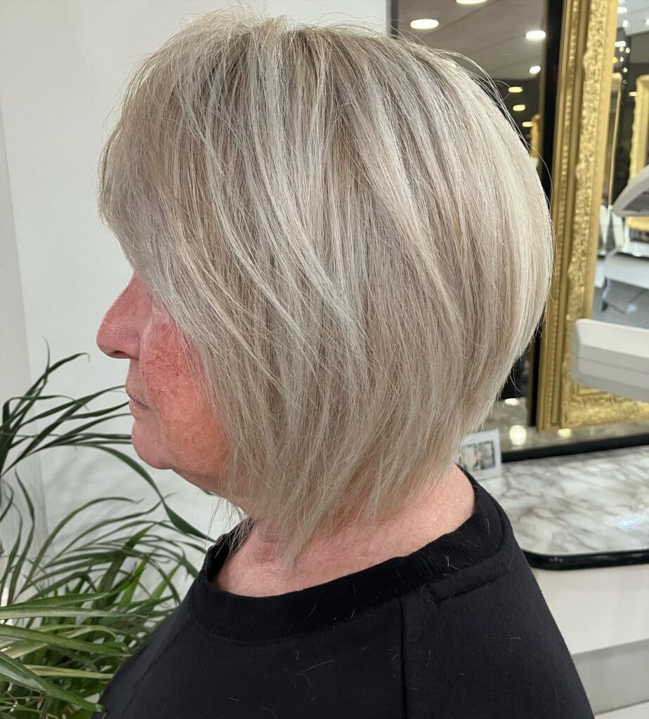 Smooth icy ash-blonde layered bob with soft volume and a sleek polished finish.