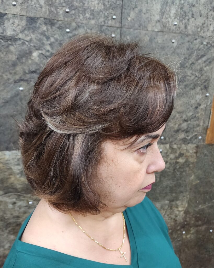 Soft cocoa brown layered bob with wispy feathered layers and a rounded shape.