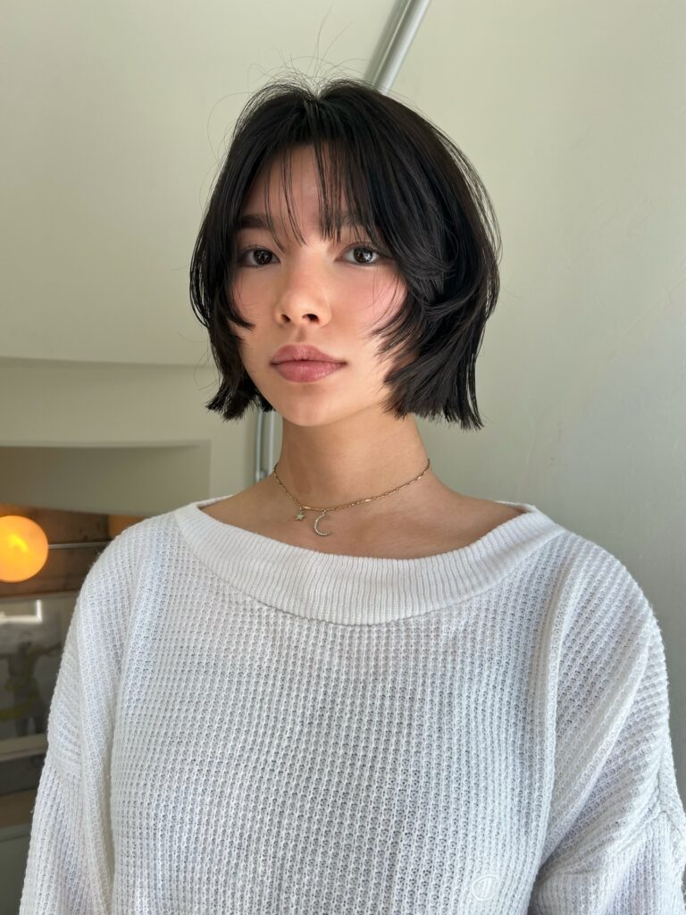 Dark brunette French bob with wispy fringe and piecey layered ends.