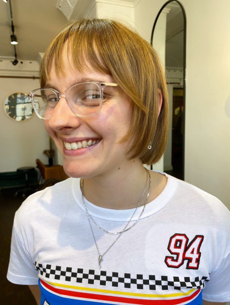 Rounded blonde bob with soft fringe and smooth tucked under layers.