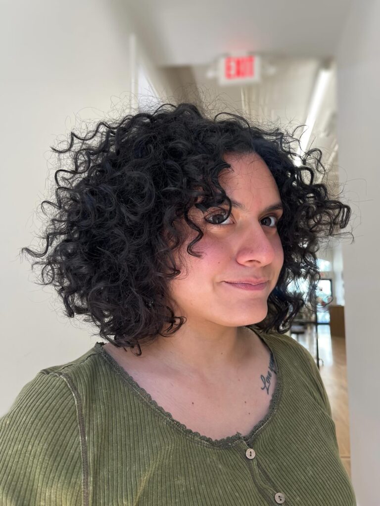 Rounded layered bob with dark soft coils and airy natural volume.