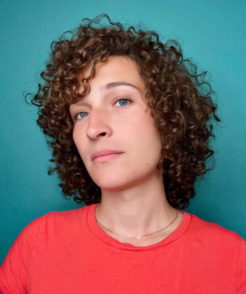 A rounded layered bob with chestnut brown ringlets and soft voluminous curls.