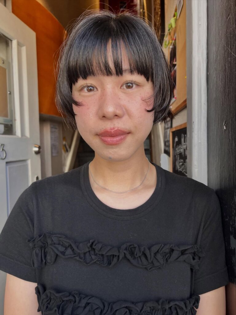 Short black micro bob with soft fringe and lightly flipped sleek ends.