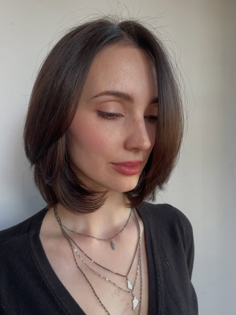 Ash blonde precision bob with sleek straight layers and tucked-under ends.