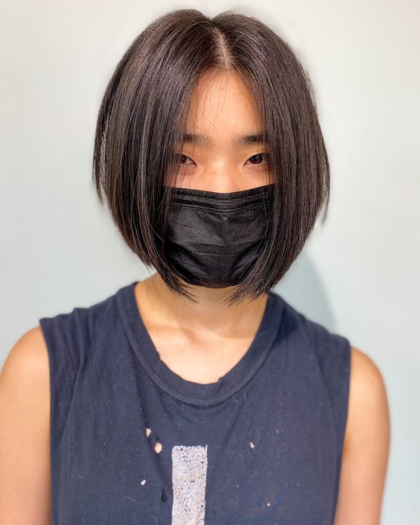 A straight-angled bob with longer front layers and a sleek, dark, glossy finish.